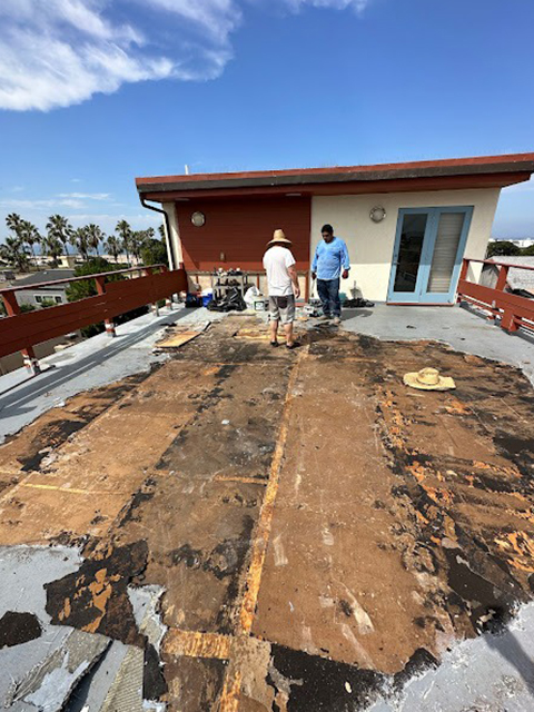 Worker applying balcony coating with roller